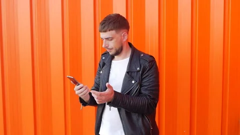 A young man with a beard knocks his hand on the phone, the phone does not catch Stock Footage 102298581