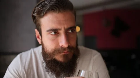 Young man with a beard listen to the guest, then drink a glass of white wine Stock Footage 61496827