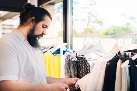 Young man with beard, looking and buying clothes, in fashion shop. shopping Stock Photos
