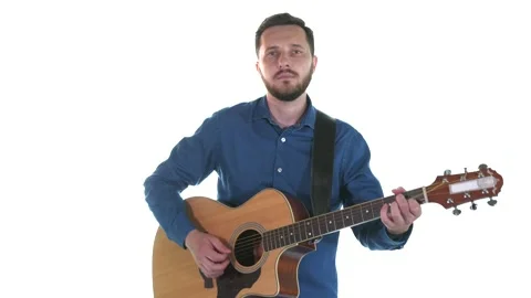 Young man with a beard playing acoustic guitar. White background. Isolated Stock Footage 135235480