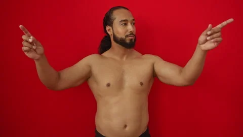 Young man with beard pointing in different directions against a vivid red b.. Stock Footage 298007286