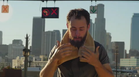 A young man with a beard pouring water over his head after an intense workout, s Stock Footage 68537348