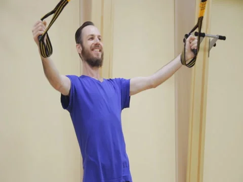 Young man with beard pulling up, doing physiotherapy exercises in fitness room Stock Footage 79375440