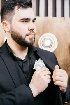 Young man with beard Putting dollars Money In His Pocket Stock Photos
