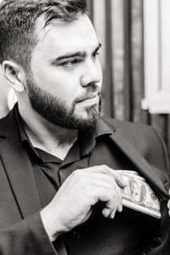 Young man with beard Putting dollars Money In His Pocket Stock Photos