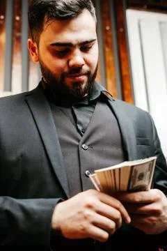 Young man with beard Putting dollars Money In His Pocket Stock Photos