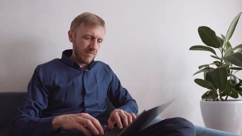 Young man with a beard running on a laptop 스톡 동영상 128296784