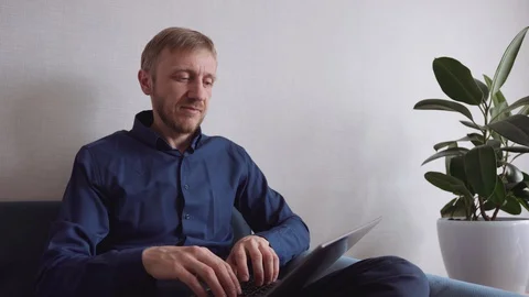 Young man with a beard running on a laptop Stock Footage 128302976