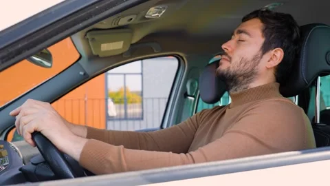 A young man with a beard sits behind the wheel and rests after a hard days work. Stock Footage 271310440