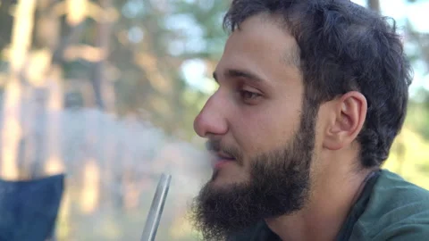 Young man with a beard smokes a hookah Stock Footage 141147321
