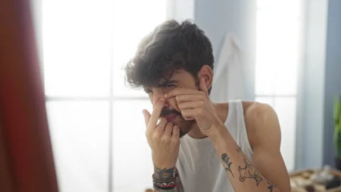 Young man with a beard squeezing a pimple on his face in an indoor beauty s.. Stock Footage 286278227