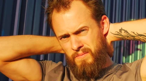 A young man with a beard stretching and working out in urban environment. 動画素材 67981439