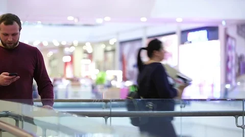 Young man with beard talking on the phone at the Mall Stock Footage 73993880