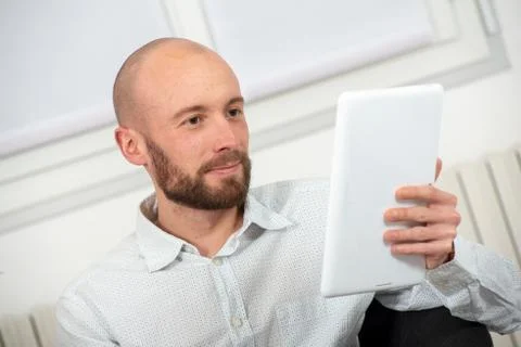 Young man with a beard using a digital tablet Stock Photos