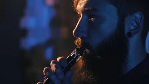 Young man with beard vaping an electronic cigarette. Vaper hipster smoke Stock Footage 80985180