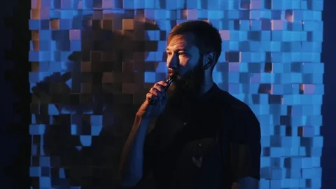 Young man with beard vaping an electronic cigarette. Vaper hipster smoke Stock Footage 80985321