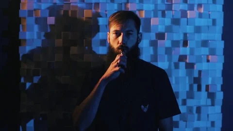 Young man with beard vaping an electronic cigarette. Vaper hipster smoke Stock Footage 80985323