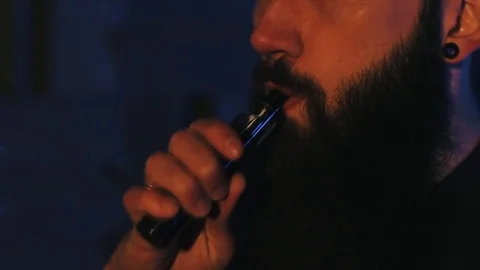 Young man with beard vaping an electronic cigarette. Vaper hipster smoke Stock Footage 80985383