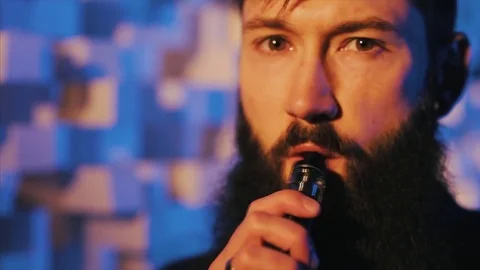 Young man with beard vaping an electronic cigarette. Vaper hipster smoke Stock Footage 80985521