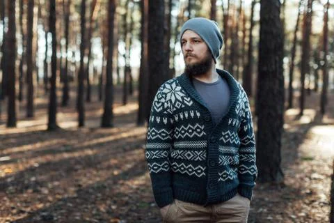 A young man with a beard walks in a pine forest. Portrait of a brutal bearded Foto stock