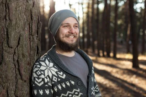 A young man with a beard walks in a pine forest. Portrait of a brutal bearded Stock Photos
