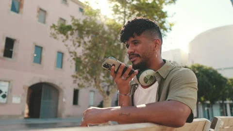 Young man with beard wearing an olive colored shirt with headphones sends voice Stock Footage 226856185