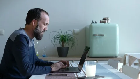 Young man with a beard working with his laptop in his modern home Stock Footage 122386710