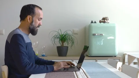 Young man with a beard working with his laptop in his modern home Stock Footage 122386768