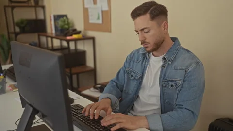 Young man with beard working in an office environment, focused on computer .. Stock Footage 314273096