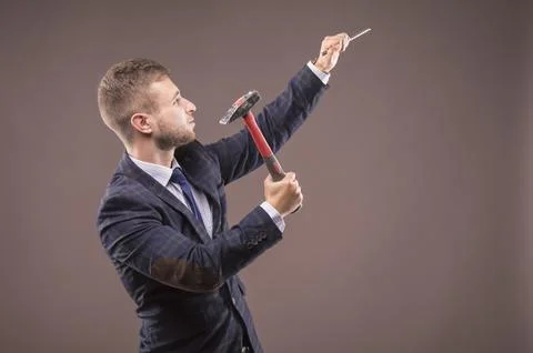 Young man beats hammer on the chisel Stock Photos