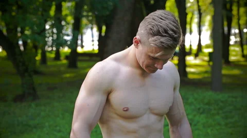 Young man with a beautiful healthy, physically fit body looks Vídeos de archivo 64916290