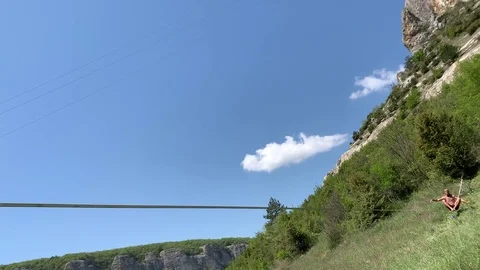 A young man with a beautiful torso is walking along a slackline. Stock Footage 108105208