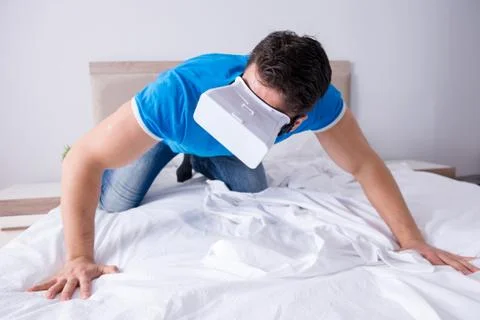 Young man in bed wearing a vr virtual reality head set Stock Photos