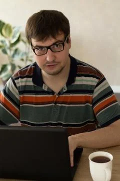 Young Man Behind a Laptop Drinking Tea Stock Photos