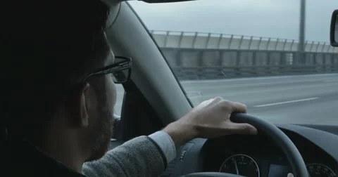 The young man behind the wheel of a car on the highway, talking on the phone Stock Footage 63358768