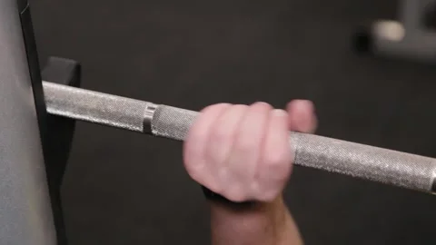 Young man bench pressing a barbell in a gym Stock Footage 337766476