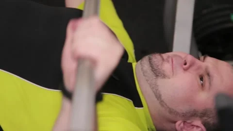 Young man bench pressing a barbell in a gym Stock Footage 337766486