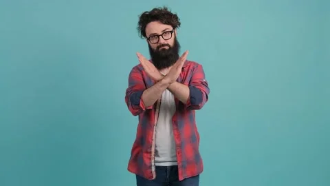 Young man with big beard with bad attitude making stop sign crossing hands. Stock Footage 140500980