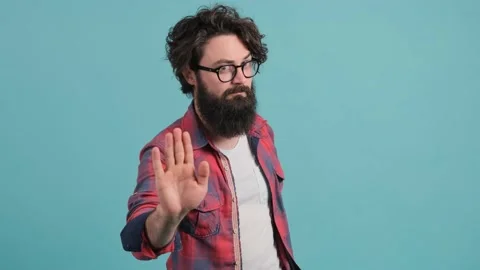 Young man with big beard with bad attitude making stop sign with hand. Stock Footage 140589811