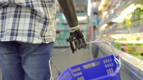 Young man with bionic prosthetic arm shopping in supermarket Stock Footage 119384720