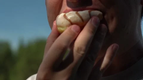 Young man Bite off donut and chew with mouth. Stock Footage 155452228