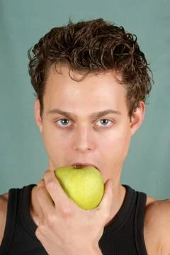 Young man biting an apple Stock Photos