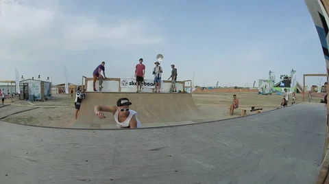 Young man in a black cap and sunglasses Riding a Skateboard in Minirampe Stock Footage 59891237
