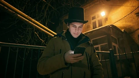 A young man in a black hat uses the phone. Shows emotions 스톡 동영상 102138222