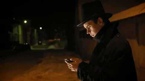 A young man in a black hat uses the phone. Shows emotions Stock-Footage 103363993