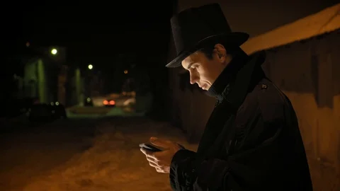 A young man in a black hat uses the phone. Shows emotions Stock-Footage 103364202
