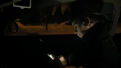 A young man in a black hat uses the phone in car. 4k Stock-Footage 103365148