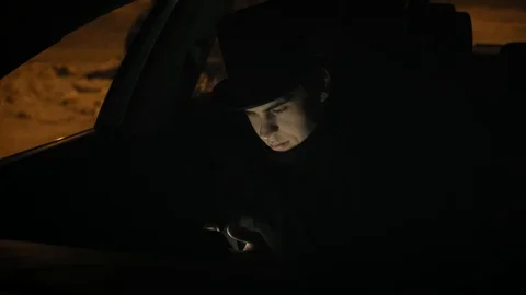 A young man in a black hat uses the phone in car. 4k Stock-Footage 103365942