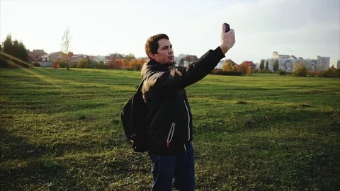 Young man in black jacket making selfie outdoor slow motion Stock Footage 69946638