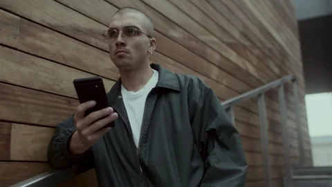 Young man in black jacket thinking and talking on the phone Stock-Footage 258198998